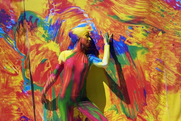 Young woman poses for photos at colorful background.