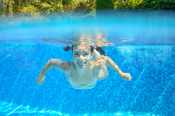 Happy child swims in pool underwater, active kid swimming, playing and having fun, children water sport