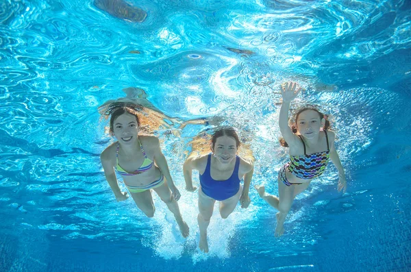 Family swim in pool or sea underwater, happy active mother and children have fun in water, kids sport on family vacation