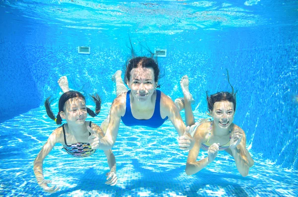 Family swim in pool underwater, happy active mother and children have fun under water, kids sport on family vacation