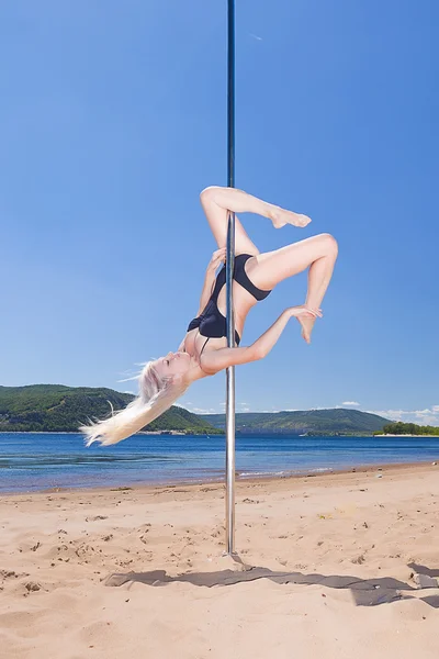 Blonde in bathing suit on pole for dancing