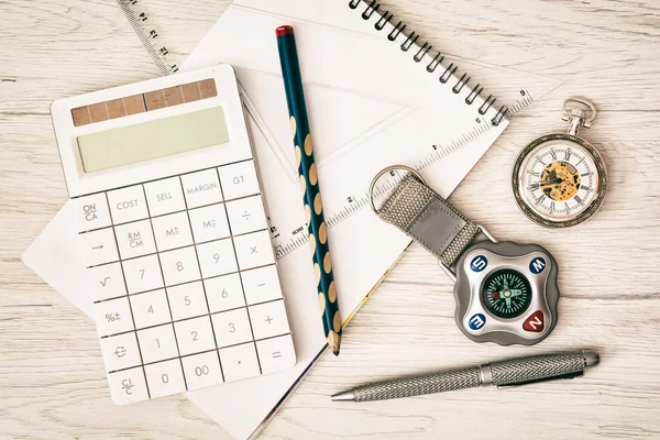 Compass, pocket watch, calculator, notepad, ruler, pen and penci