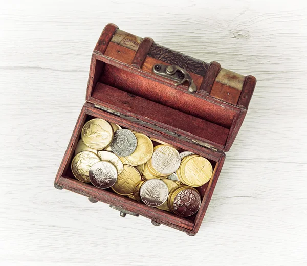 Retro wooden money chest filled with coins