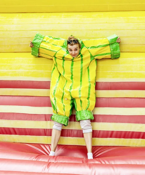Young caucasian woman in plastic dress in a bouncy castle