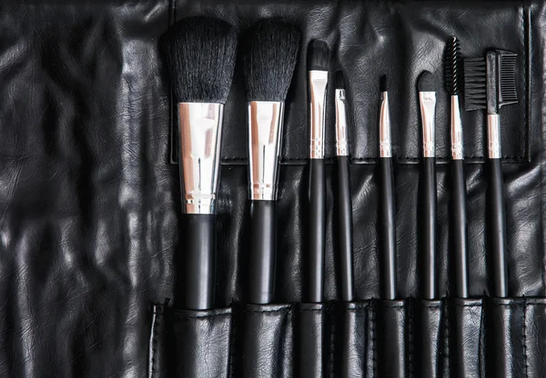 Set of cosmetic brushes in black leather bag, skin care