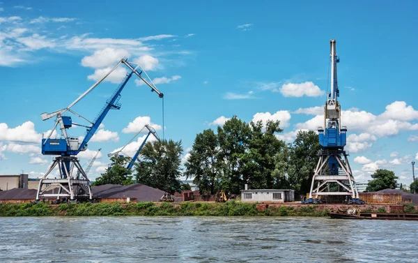 Blue cranes in cargo port, Danube river