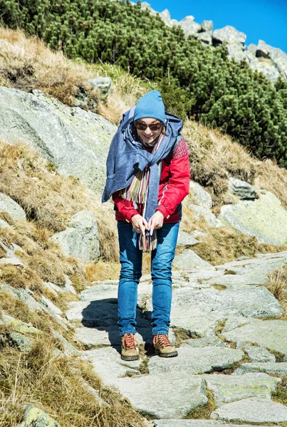 Joyful woman posing on the mountain footpath leading up the peak