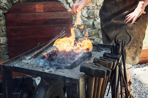 Artistic blacksmith works in the historic blacksmith workshop