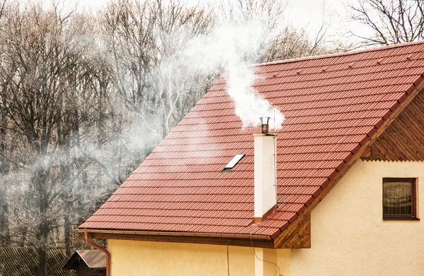 Red roof and smoking chimney