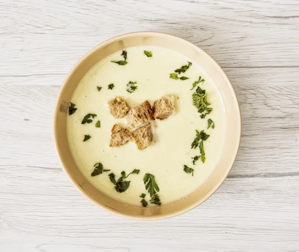 Leek soup with parsley and pieces of toasted bread, food theme