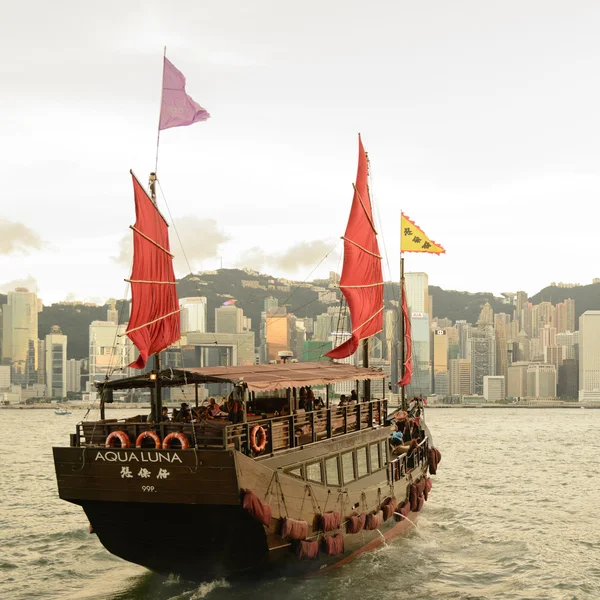 HONG KONG - SEPTEMBER 15: Victoria Harbor on September 15, 2013 in Hong Kong. An old Chinese junk departed from Ocean Terminal and drove across Victoria Harbor during sunset.