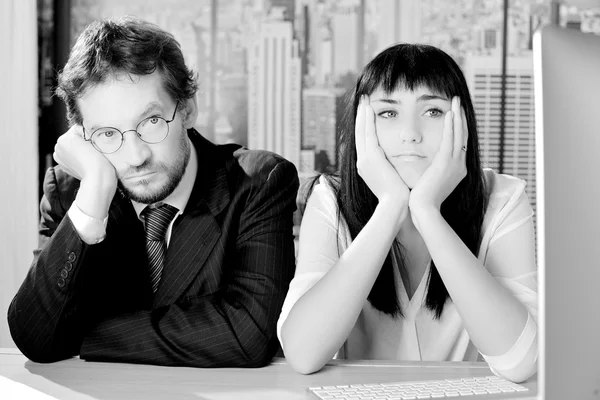 Black and white portrait of sad business people sitting in office