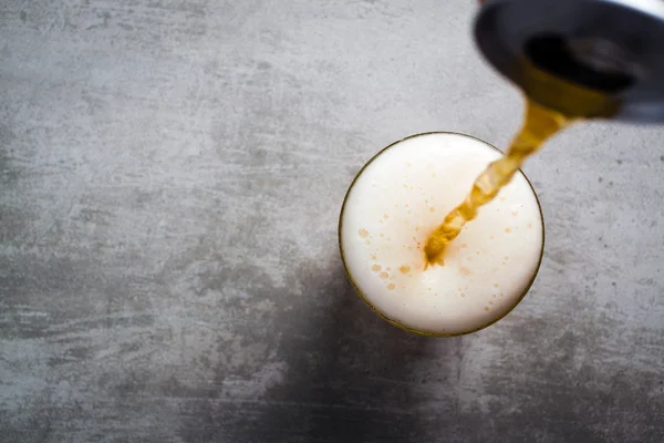 Beer pouring out of a can into a glass