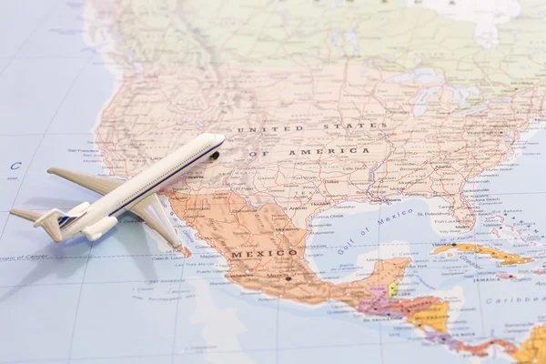 Miniature of passenger plane on a map, travel destination USA