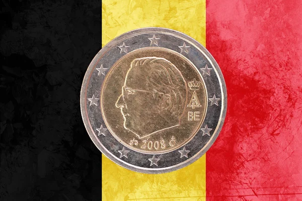 Belgian two euros coin with flag of Belgium as background
