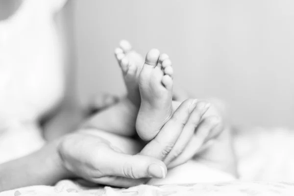 Mother\'s hands holding newborn\'s feet