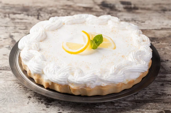 Lemon tart on a plate decorated with lemons