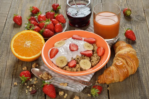 Muesli with yogurt, croissant and fresh strawberries