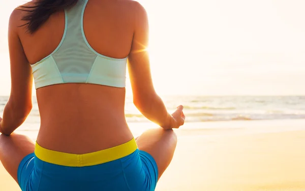 Woman Practicing Yoga on the Beach at Sunset