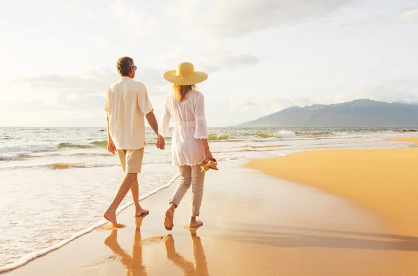 Mature Couple Walking on the Beach at Sunset