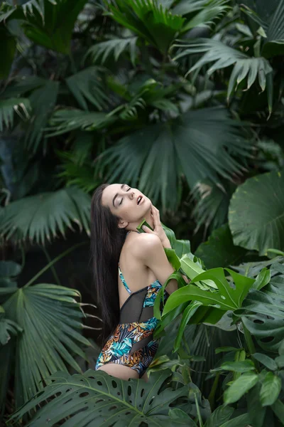 Girl in swimsuit between plants