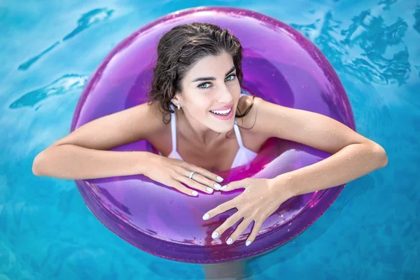 Model in rubber ring in swimming pool