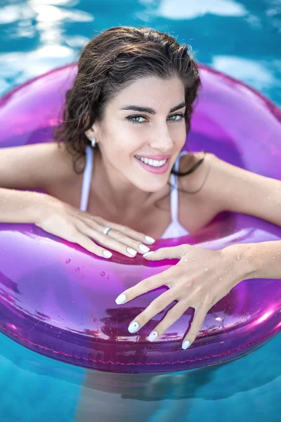 Model in rubber ring in swimming pool