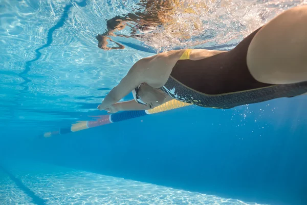 Girl swims in crawl style underwater