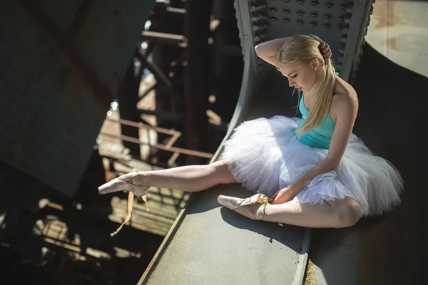 Ballerina sitting on the edge of bridge