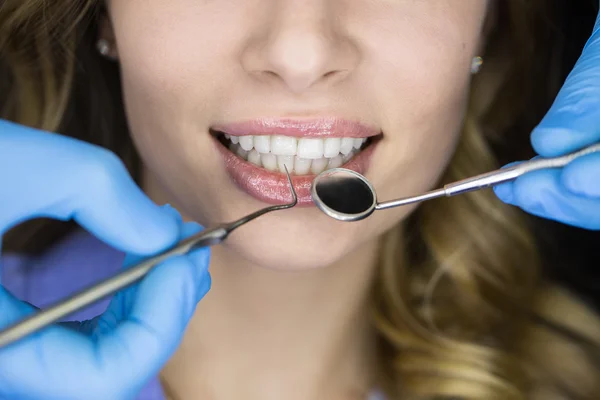 Dentist examining a patients teeth in the dentist.