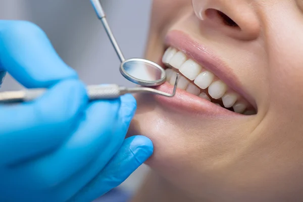 Dentist examining a patients teeth in the dentist.