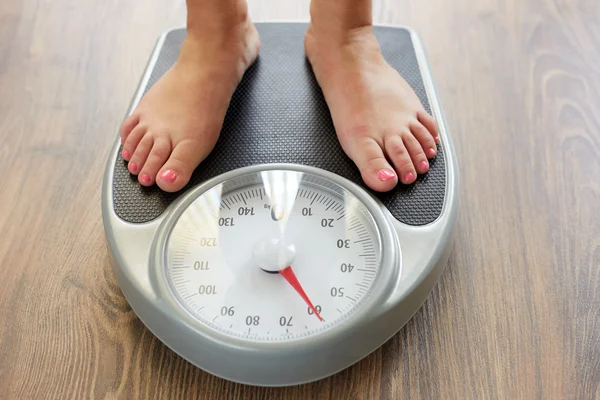 Female feet with weight scale