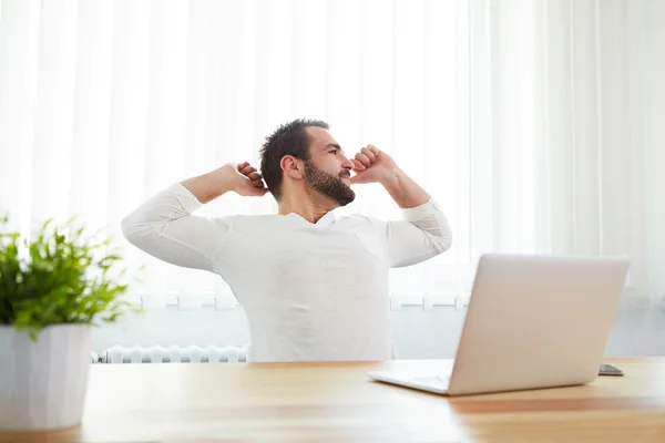 Man stretching his back at desk