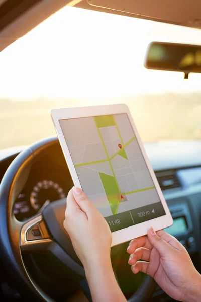Woman in the car and holding tablet with map gps navigation