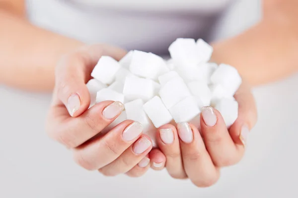 Woman holds in hands of sugar cubes