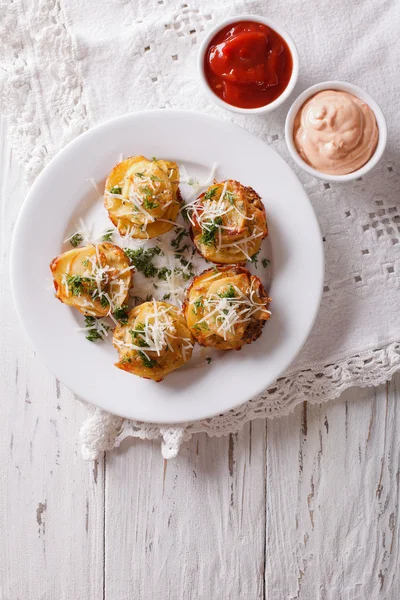 Sliced baked potato with cheese and sauce on the table. vertical