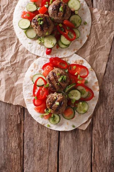 Grilled meat balls with fresh vegetables on a flat bread. Vertic