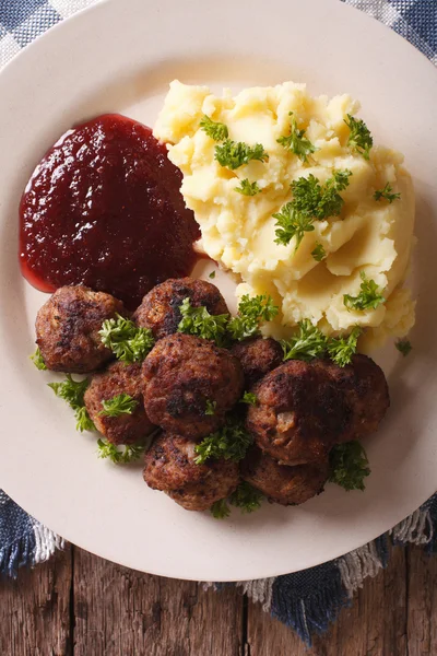 Swedish cuisine: meatballs, lingonberry sauce, potato closeup. V