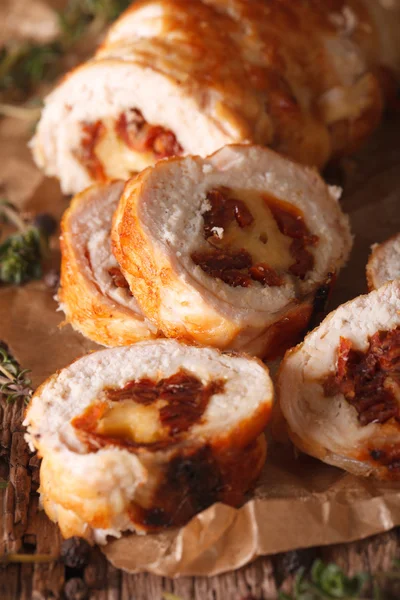 Chicken roll stuffed with cheese and sun-dried tomatoes close-up