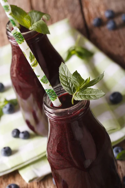 Organic blueberry juice in a glass bottle macro. vertical