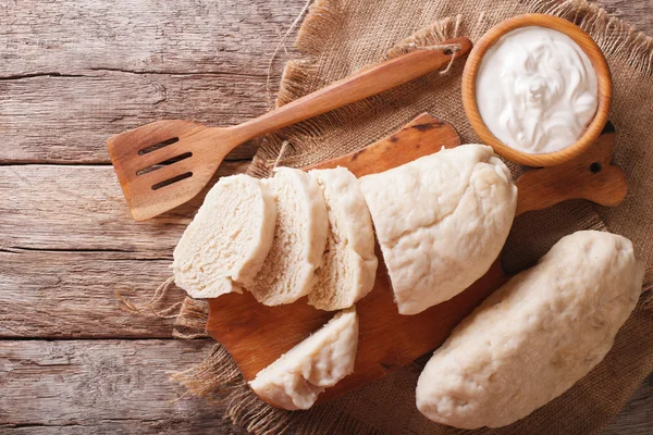 Czech cuisine: sliced boiled knedliks close-up on chopping board