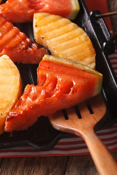 Watermelon and melon in a pan grill closeup. vertical