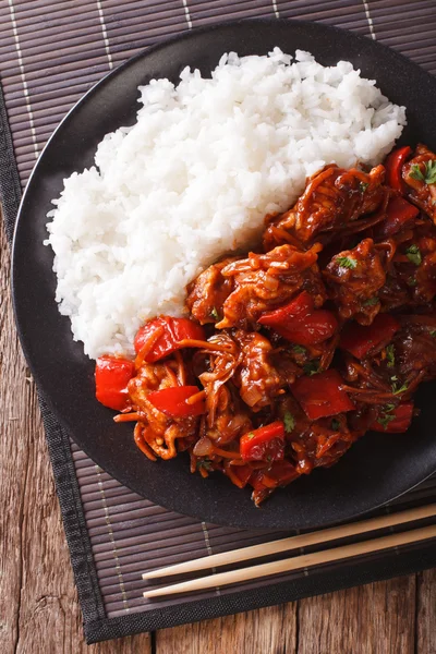 Rice with stewed pork in sweet and sour sauce closeup. Vertical