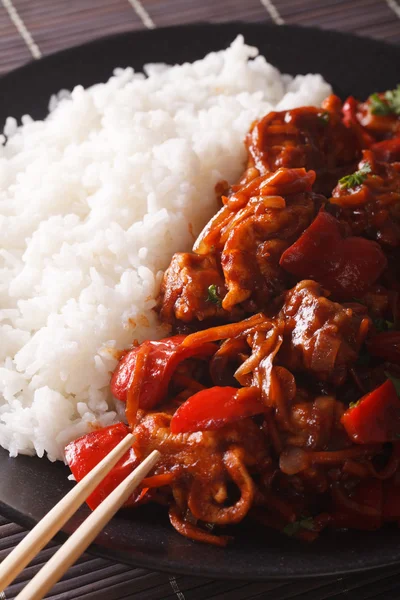 Rice with stewed pork in sweet and sour sauce closeup. vertical