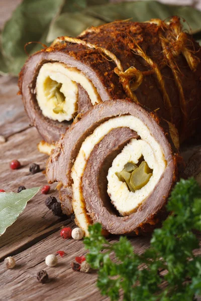Meat roll stuffed with eggs and cucumber closeup. vertical
