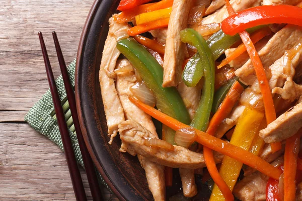 Chicken with vegetables macro and chopsticks top view