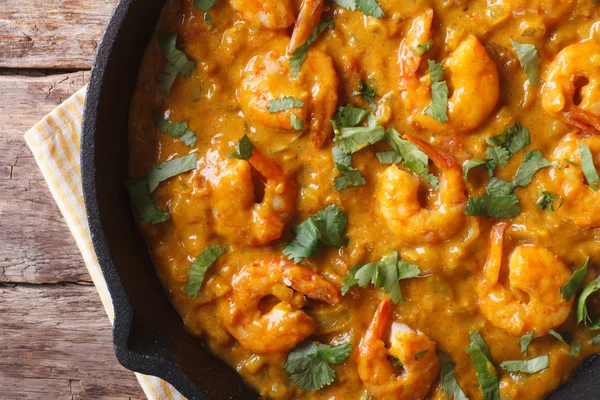 Prawns in curry sauce close-up. horizontal view from above