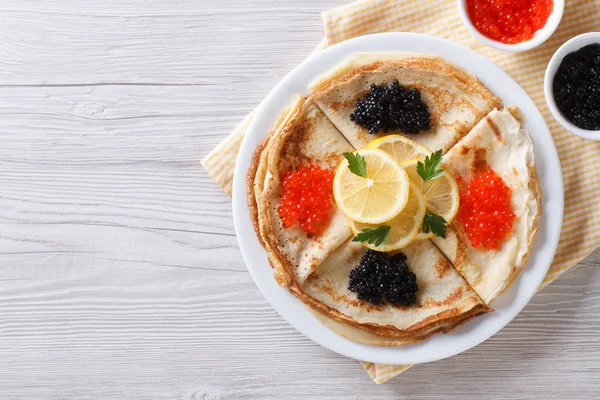 Pancakes with red and black caviar, horizontal top view