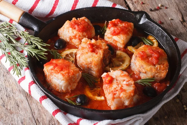 Fish fillet in tomato sauce in a pan and ingredients horizontal