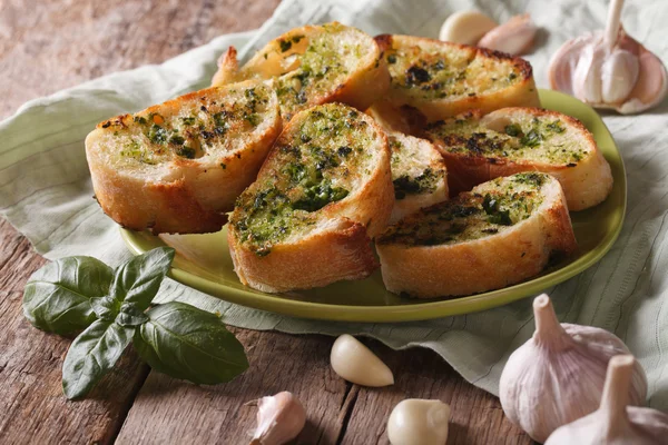 Toasts with basil and garlic close-up on a plate. horizontal